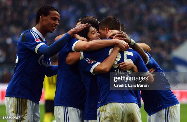 Klaas Jan Huntelaar of Schalke celebrates with Atsuto Uchida and other team mates after scoring his teams second goal during the Bundesliga match...