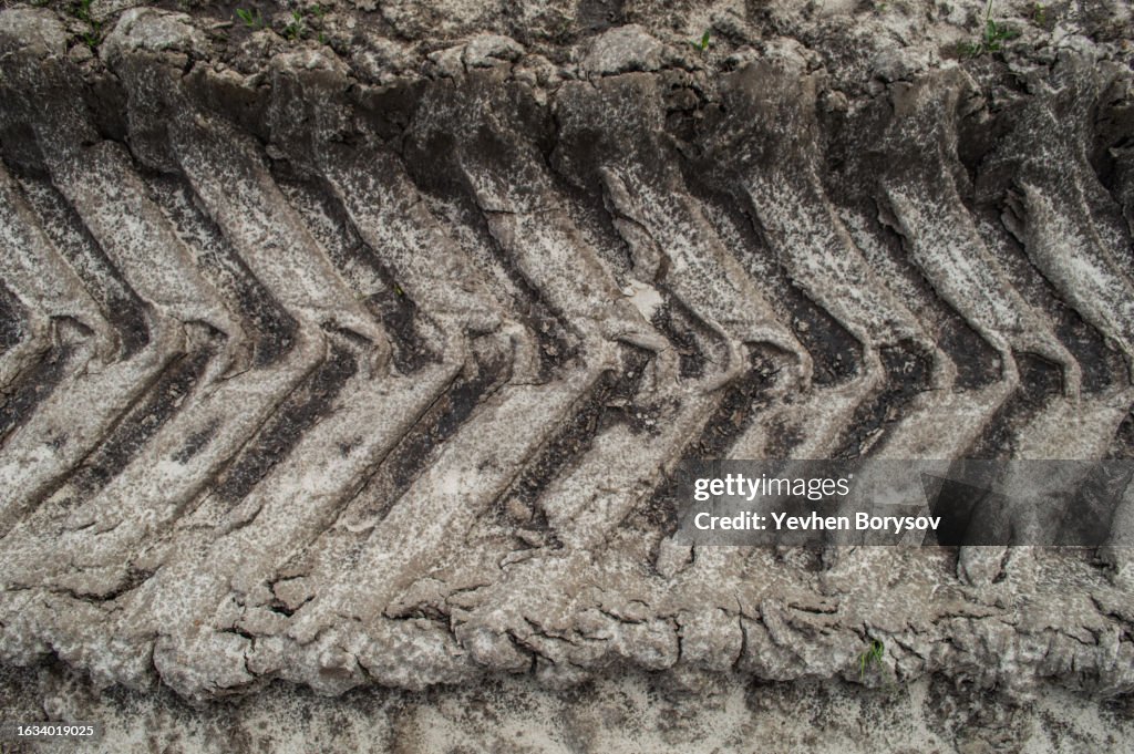 Background of tire tracks texture closeup on dirty ground