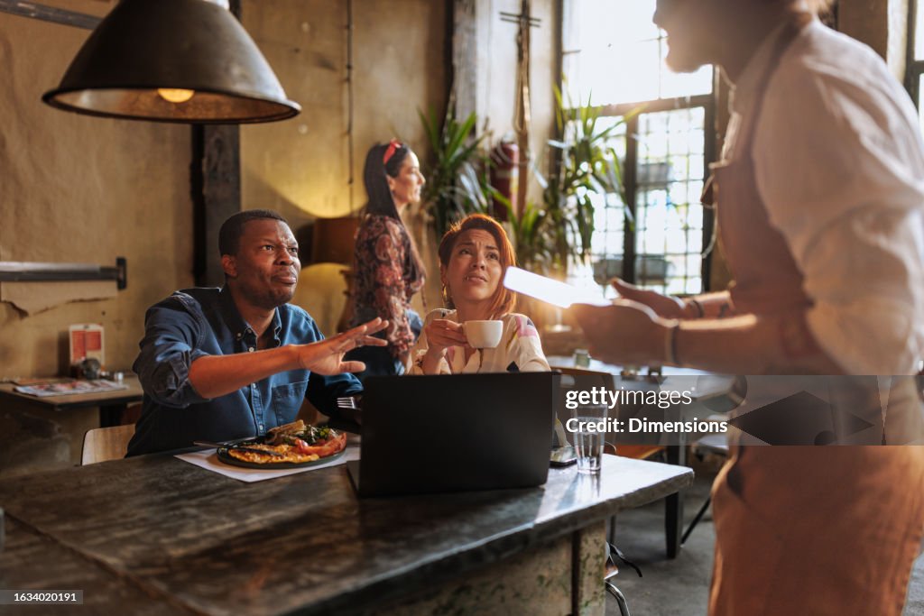 Pareja hablando con camarero en el bar