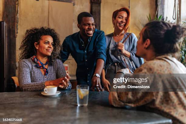 four young people having conversation while meeting in restaurant - double date stock pictures, royalty-free photos & images