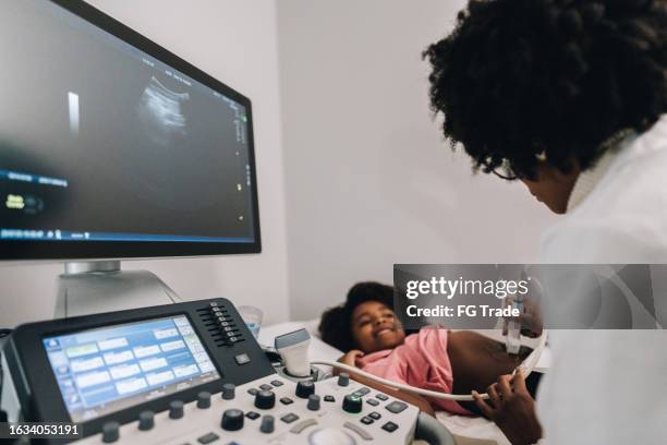 doctora joven que realiza un examen de ultrasonido a su paciente en un hospital - tecnología sanitaria fotografías e imágenes de stock