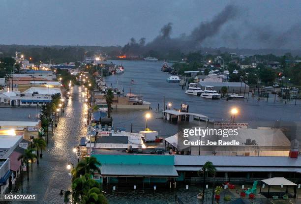 In an aerial view, a fire is seen as flood waters inundate the downtown area after Hurricane Idalia passed offshore on August 30, 2023 in Tarpon...
