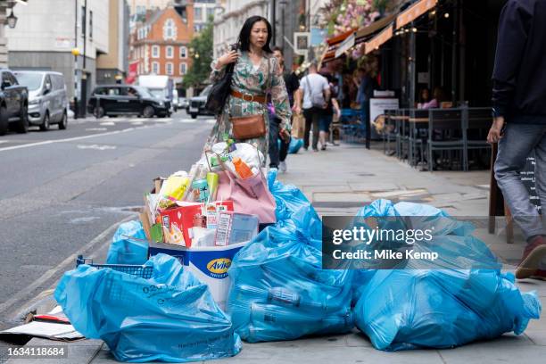 Waste in recycling bags and accumulated rubbish piled up on the pavement next to restaurants in Covent Garden on 14th August 2023 in London, United...