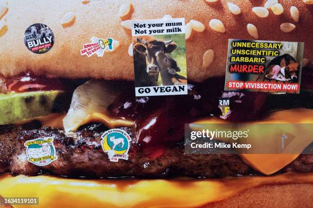 Animal rights and pro-vegan protest stickers placed onto an advertising poster for a McDonalds beef burger on 14th August 2023 in London, United...