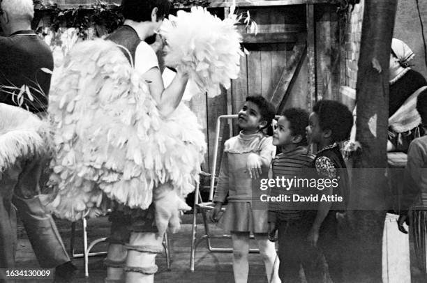 Caroll Spinney, in Big Bird costume, talks to several children on the set of Sesame Street's very first season, taken for America Illustrated...