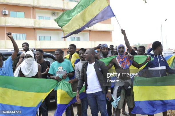 Residents holding Gabon national flags celebrate in Libreville on August 30, 2023 after a group of Gabonese military officers appeared on television...