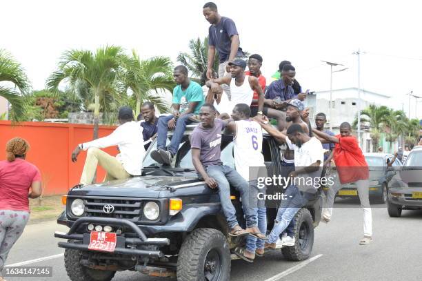 Residents driving in a vehicle celebrate and hold a Gabon national flag in Libreville on August 30, 2023 after a group of Gabonese military officers...