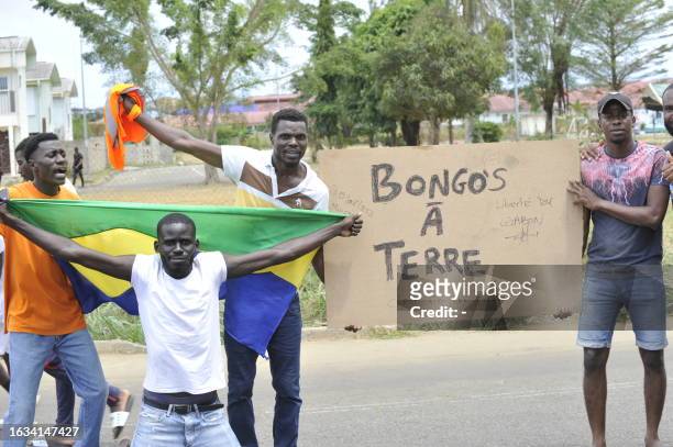Residents hold a Gabon national flag as they celebrate in Libreville on August 30, 2023 after a group of Gabonese military officers appeared on...