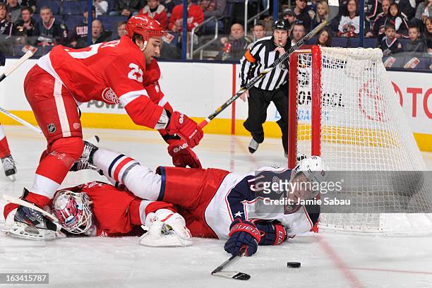 Ryan Johansen of the Columbus Blue Jackets continues to play the puck after being checked by Kyle Quincey of the Detroit Red Wings during the first...
