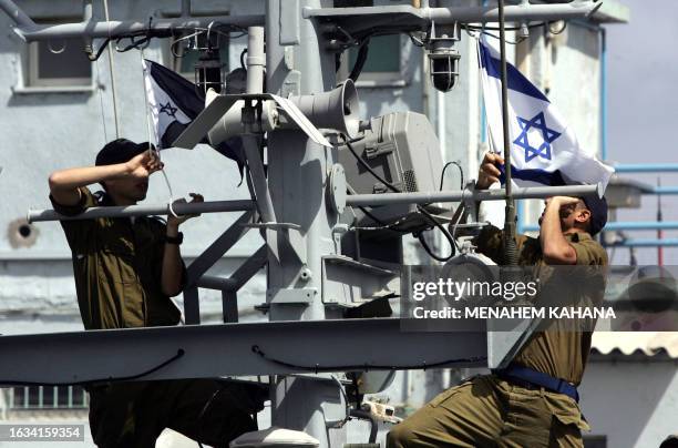 Israeli sailors raise the national and navy flags as they ready to go out on patrol on the "Devora" gunship from their base in the portal city of...