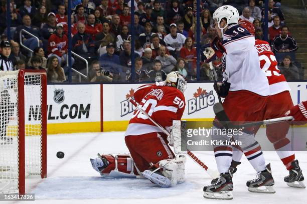 Ryan Johansen of the Columbus Blue Jackets watches as Jonas Gustavsson of the Detroit Red Wings is unable to stop a shot from Jack Johnson of the...