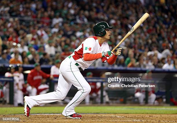 Eduardo Arredondo of Mexico hits a RBI sacrifice fly out against Canada during the fourth inning of the World Baseball Classic First Round Group D...