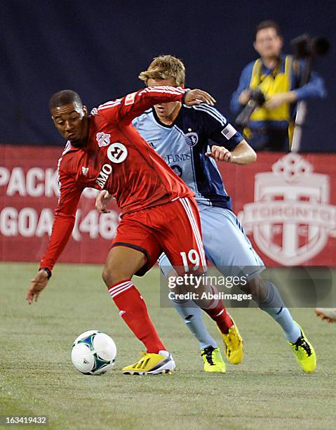 Reggie Lambe of Toronto FC controls the ball against Chance Myers of Sporting Kansas City at the Rogers Centre on March 9, 2013 in Toronto, Ontario,...