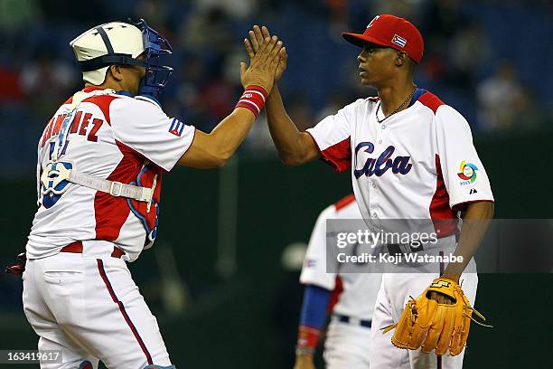 Pitcher Raciel Iglesias and Catcher Eriel Sanchez of Cuba celebrate after winning during the World Baseball Classic Second Round Pool 1 game between...