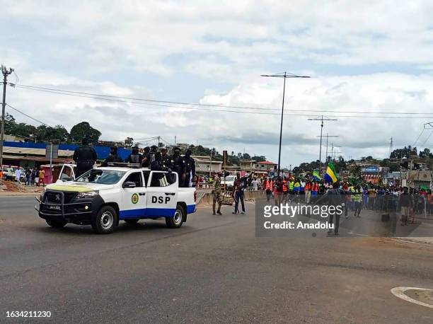 Officers from Department of Public Security patrol as supporters of the military administration gather on a street after Gabonese army officers enter...