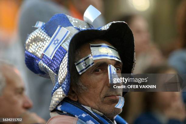 An Israeli man wearing a floppy hat adorned with the national flag sits in Rabin Square, named after assassinated Labour leader Yitzhak Rabin, as he...