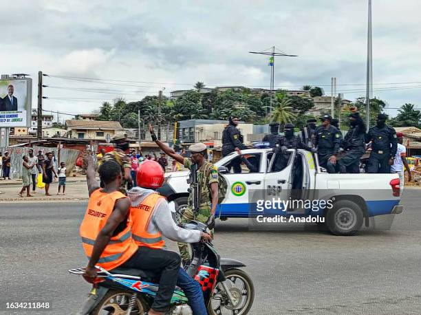 Officers from Department of Public Security patrol as supporters of the military administration gather on a street after Gabonese army officers enter...