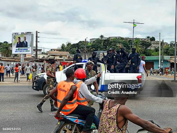 Officers from Department of Public Security patrol as supporters of the military administration gather on a street after Gabonese army officers enter...