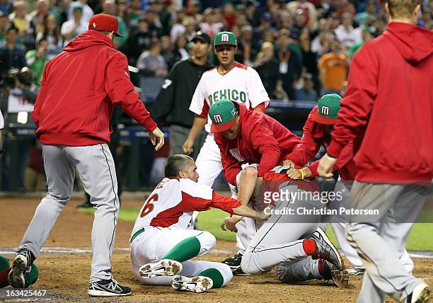Pitcher Oliver Perez and coaches of Mexico attempt to subdue Scott Mathieson of Canada during an on field altercation between both teams in the World...
