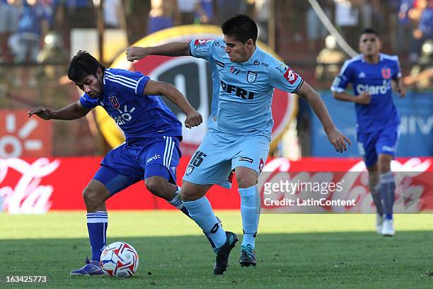 Ramon Fernandez of Universidad de Chile struggles for the ball with Fernando Manriquez of Deportes Iquique during a match between Universidad de...