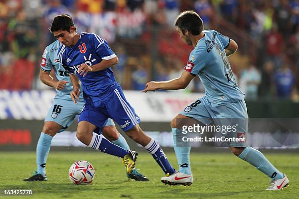 Sebastian Martinez of Universidad de Chile struggles for the ball with Fernando Manriquez and Mauricio Zenteno of Deportes Iquique during a match...