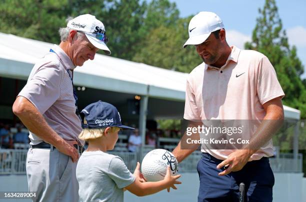 Scottie Scheffler of the United States signs autographs during a practice round prior to the TOUR Championship at East Lake Golf Club on August 23,...