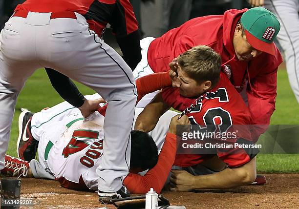 Eduardo Arredondo of Mexico fights with Jay Johnson of Canada during the World Baseball Classic First Round Group D game at Chase Field on March 9,...
