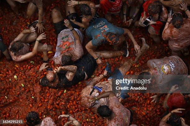 People covered in tomato pulp take part in the 76th 'Tomatina' Festival in the eastern town of Bunol, Spain on August 30, 2023. Approximately 15,000...