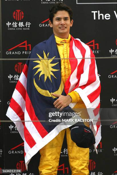Alex Yoong from A1 Team Malaysia, drapes himself in his national flag after finishing second in the feature race and winning the sprint race of the...