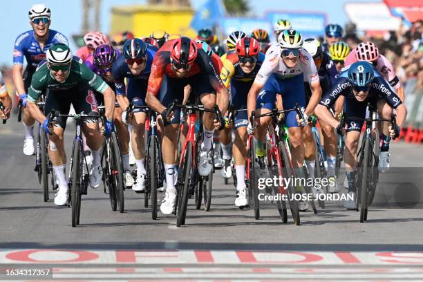 Stage winner Team Alpecin's Australian rider Kaden Groves sprints to cross the finish line with second placed Team Ineos' Italian rider Filippo Ganna...