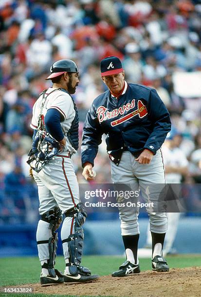 Manager Chuck Tanner of the Atlanta Braves talks with catcher Ozzie Virgil while making a pitching change during an Major League Baseball game circa...