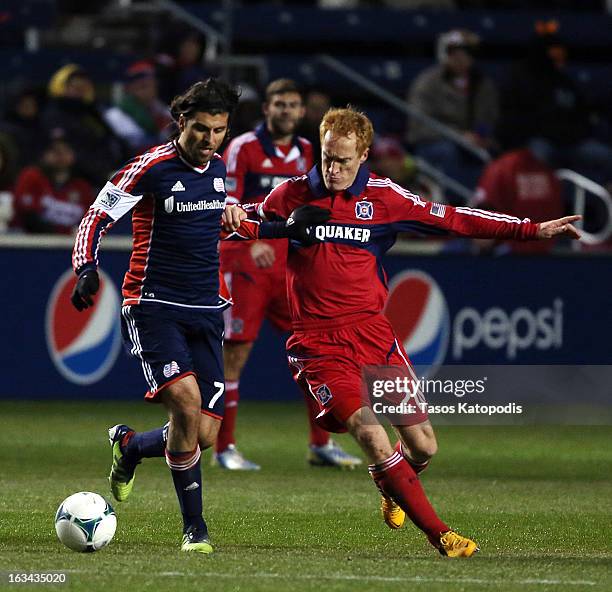 Juan Toja of New England Revolution and Jeff Larentowicz of Chicago Fire fight for the ball at Toyota Park March 9, 2013 in Bridgeview, Illinois.