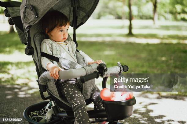kind sitzt im kinderwagen. - baby stroller stock-fotos und bilder