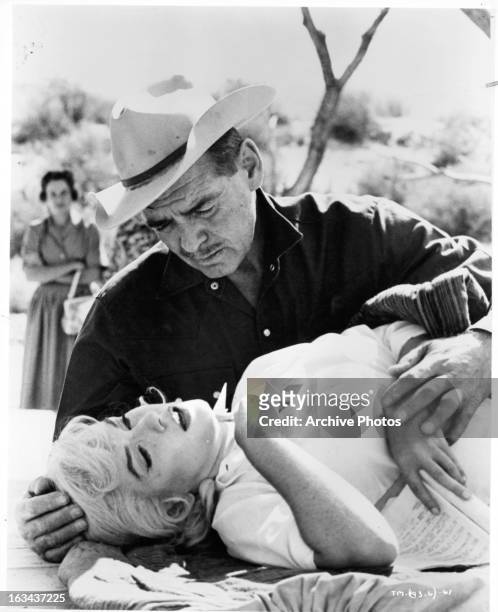 Clark Gable leaning over Marilyn Monroe in a scene from the film 'The Misfits', 1961.