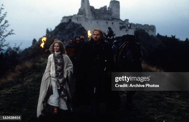 Julie Christie and Dennis Quaid walking from castle in a scene from the film 'DragonHeart', 1996.