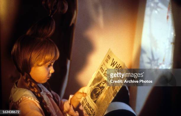 Taylor Momsen reading newspaper about the Grinch in a scene from the film 'How The Grinch Stole Christmas', 2000.