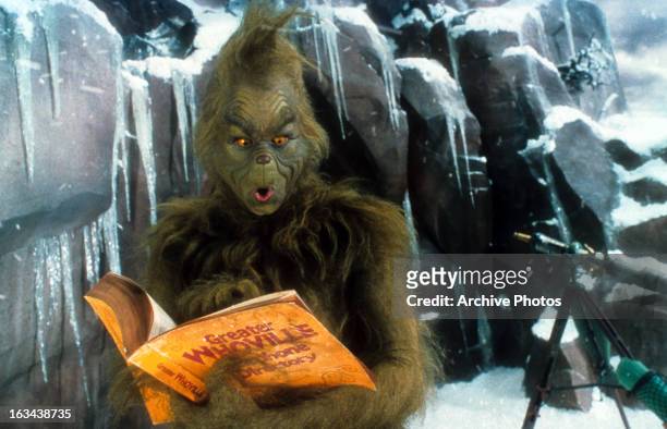Jim Carrey looking through phone directory in a scene from the film 'How The Grinch Stole Christmas', 2000.