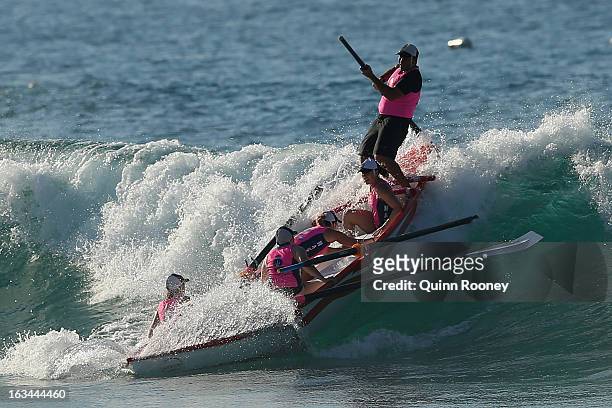 The crew from Lorne catch a wave in the surf boat race during the Victorian Surf Lifesaving Championships on March 10, 2013 in Anglesea, Australia.