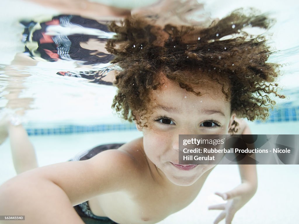 USA, Utah, Orem, Boy (4-5) swimming in pool