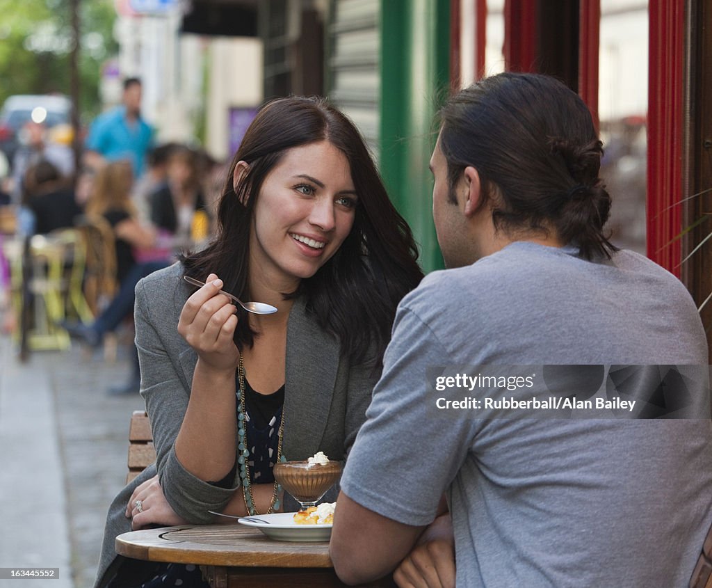France, Couple sitting in sidewalk cafe