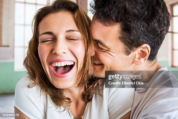 romantic couple laughing and hugging intimately - tomber amoureux photos et images de collection