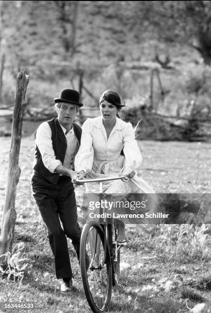 American film actor Paul Newman steadies a bicycle for actress Katherine Ross in a scene from the film 'Butch Cassidy and the Sundance Kid' ,...