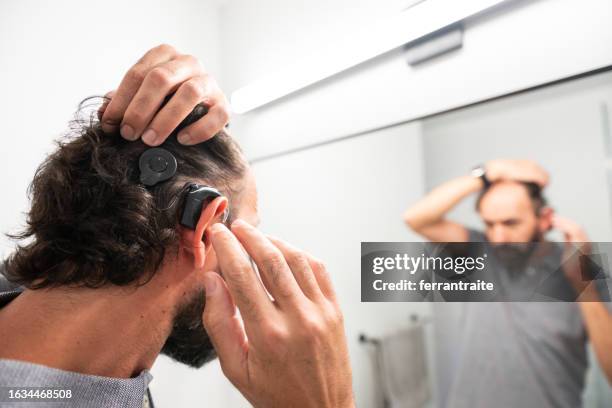 persona sorda insertando implantes cocleares - cochlear implant fotografías e imágenes de stock
