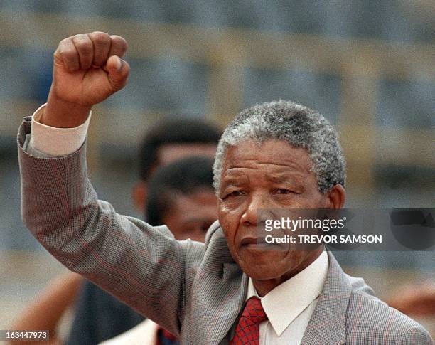 Anti-apartheid leader and African National Congress member Nelson Mandela raises clenched fist, arriving to address mass rally, a few days after his...