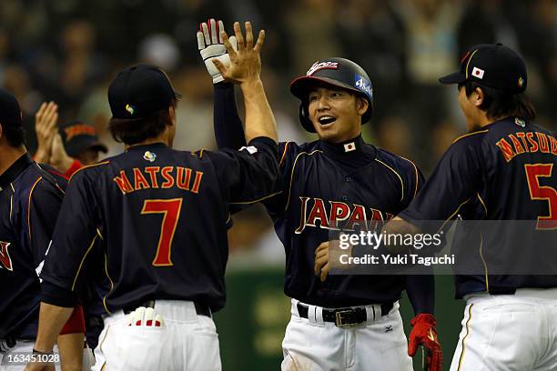 Takashi Toritani of Team Japan is greeted by teammates after scoring the game tying run in the top of the ninth inning during Pool 1, Game 2 between...