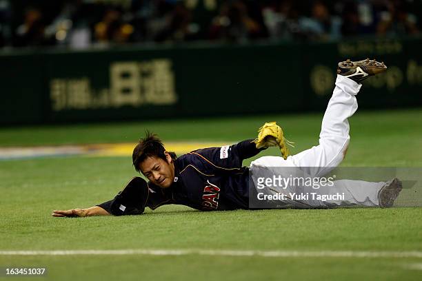 Kazuhisa Makita of Team Japan makes a diving catch on a Dai-Kang Yang bunt in the bottom of the ninth inning during Pool 1, Game 2 between Japan and...