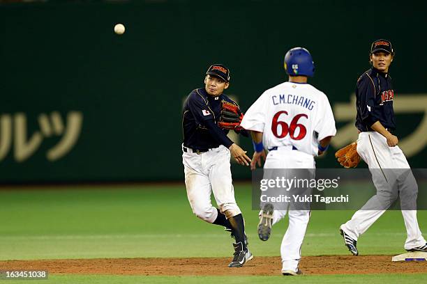 Takashi Toritani of Team Japan turns the game ending double play in the bottom of the 10th inning during Pool 1, Game 2 between Japan and Chinese...