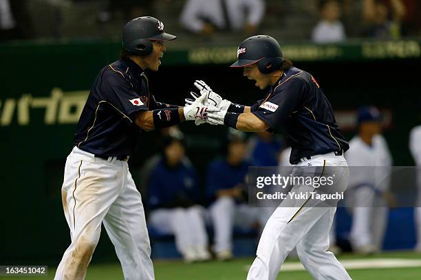 Nobuhiro Matsuda of Team Japan celebrates with Atsunori Inaba of Team Japan after scoring the go ahead run in the top of the 10th inning during Pool...