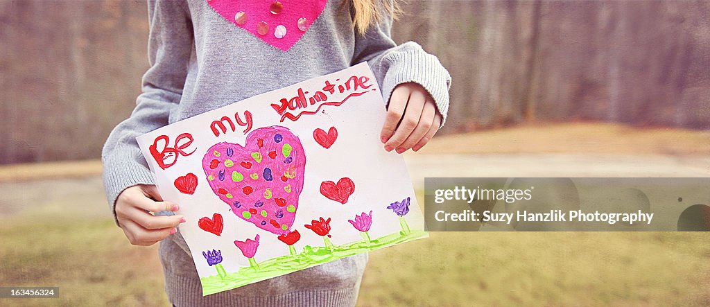 Girl holding Valentines Card with pink heart