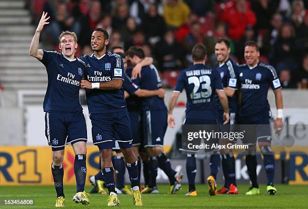 Artjoms Rudnevs of Hamburg celebrates his team's third goal with team mate Dennis Aogo and others during the Bundesliga match between VfB Stuttgart...